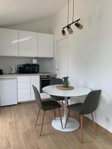 a kitchen with a table and chairs in a kitchen at Studio neuf avec Terasse Jardin in Seignosse +9 photos