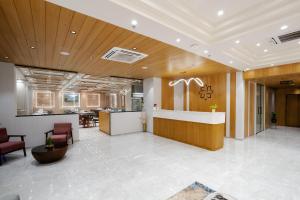 een kantoorlobby met receptiebalie en stoelen bij Prarambh By Siara in Nadiād +45 foto's