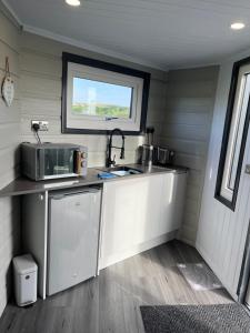 a small kitchen with a sink and a microwave at Studio room with amazing views in Abersoch