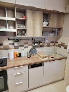 a kitchen with white cabinets and a wooden counter top at Florida Apartment in Gevgelija