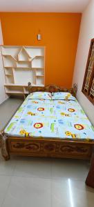 a bedroom with a bed with a bedspread with animals on it at Sri Annai Home Stay III in Tiruvannāmalai