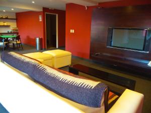 a living room with a couch and a flat screen tv at MIL810 Ushuaia Hotel in Ushuaia