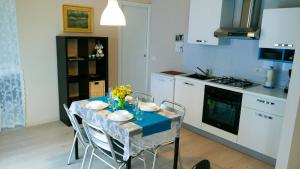 una cucina con tavolo, sedie e panna blu di Casa Domenica a Baveno