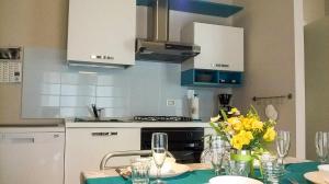 una cucina con tavolo e vaso di fiori gialli di Casa Domenica a Baveno