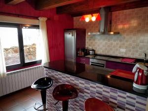 une cuisine avec des murs rouges et des tabourets rouges dans l'établissement La Casona del Silencio, à Aldehuela de Periañez 22 autres photos