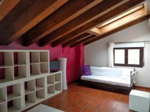 une chambre avec un lit et un mur rouge dans l'établissement La Casona del Silencio, à Aldehuela de Periañez