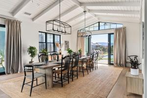 a dining room with a long table and chairs at Vintners Village California-Chic Wine Estate in Country Road Estates