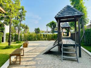ein Spielplatz mit Rutsche und Bänken in einem Park in der Unterkunft Mouana Breeze Mai Khao 4-bedroom Pool Villa 9920 in Mai Khao Beach