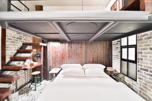 a bedroom with a white bed and a brick wall at Daegu February Hotel Hwanggeum in Daegu +94 photos