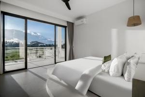 乌布Villa Chai - 2 BR in Ubud的卧室里有一张白色的床和一扇大窗户