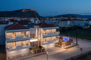 a building with a view of a city at night at Pantheon Suites Gaitis in Nafplio