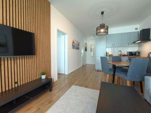 Una sala de estar con televisión y un comedor. en Apartament Baltic Sauna Break e-apart, en Władysławowo 10 fotos más