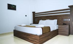 um quarto com uma cama grande com cabeceira de madeira em Misty Garden Resort and SPA em Munnar mais 84 fotografias