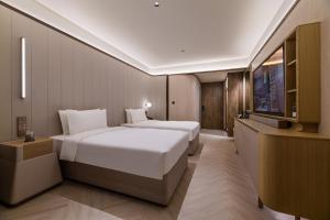 Ένα ή περισσότερα κρεβάτια σε δωμάτιο στο Crystal Orange Shanghai Lujiazui Financial Center Hotel