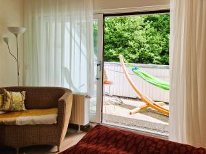 a living room with a couch and a hammock on a balcony at Ferienwohnung in Triberg am Waldrand - idyllisch, ruhig, erholsam in Triberg +46 photos