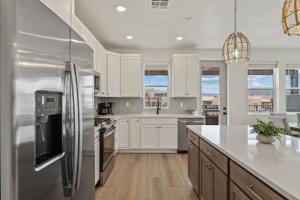 a kitchen with white cabinets and a stainless steel refrigerator at Periwinkle Sky condo in St. George