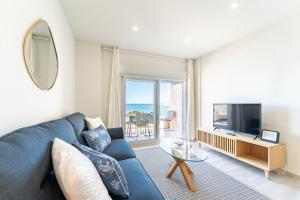 a living room with a blue couch and a television at Amazing Rey de España Views in Fuengirola +20 photos