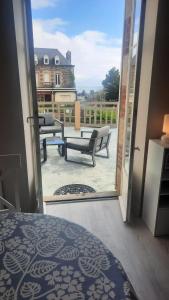 une pièce avec une porte ouverte sur un patio avec des bancs dans l'établissement Appartement convivial Saint-Quay-Portrieux 60 m² avec terrasse, à Saint-Quay-Portrieux