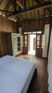 a bedroom with a white bed in a wooden room at NEW The Loft - Uluwatu Surf Ranch in Uluwatu