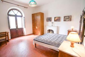 ポルトフェッラーイオにあるAppartamento Podere San Marco - Bilocaleのベッドルーム(ベッド1台、窓、暖炉付)