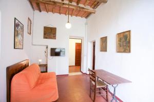 ポルトフェッラーイオにあるAppartamento Podere San Marco - Bilocaleのリビングルーム(オレンジ色のソファ、テーブル付)