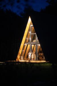 two people standing in the window of a house at night at A-Park Bologa in Bologa