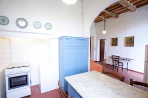 a kitchen with a blue cabinet and a table at Appartamento Podere San Marco - Bilocale in Portoferraio