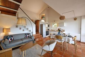 a living room with a couch and a table and chairs at Sous le Pin - Villa paisible face aux îles Lavezzi in Bonifacio +28 photos
