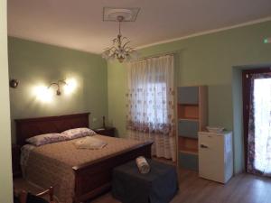 a bedroom with a bed and a chandelier at affittacamere La Betulla in Pettinengo