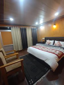 ein Schlafzimmer mit einem großen Bett und einem Stuhl in der Unterkunft Tiri Ratna Cottage in Jāmb