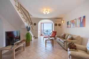 a living room with a couch and a tv at Sea Whisper Home -Sunset, Sea, Easy Stay, Shops in Praiano