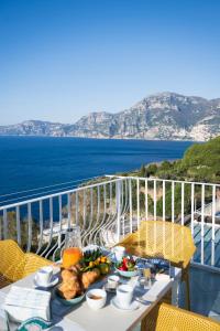a table with a plate of food on a balcony at Sea Whisper Home -Sunset, Sea, Easy Stay, Shops in Praiano