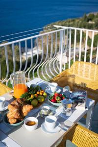 a table with food and drinks on a balcony at Sea Whisper Home -Sunset, Sea, Easy Stay, Shops in Praiano