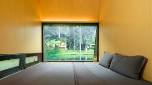 a room with a large window with a bed in front of it at Bobocabin Ranca Upas, Bandung in Bandung