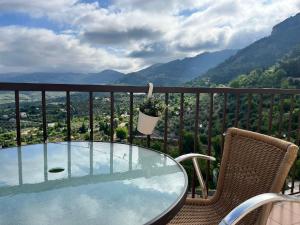 een glazen tafel en stoelen op een balkon met uitzicht bij Apartamentos Fuente La Raja in La Iruela