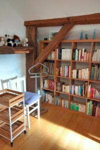 a room with a book shelf filled with books at Gite le grenier du roc in Thiéfosse