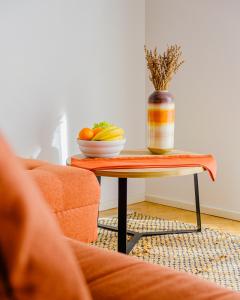 a table with a bowl of fruit and a vase on it at Apartments in Villa Azur in Novi Vinodolski