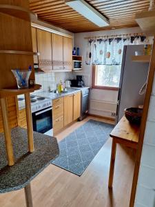 una cucina con mobili in legno e un forno a piano cottura di Rauhan pesä a Karigasniemi