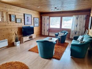 un soggiorno con 2 sedie blu e una TV di Rauhan pesä a Karigasniemi