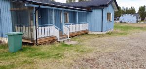 una casa blu con un bidone della spazzatura davanti di Rauhan pesä a Karigasniemi