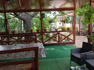 a patio with a table and a fence with potted plants at Casa Maria in Jurilovca