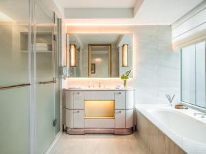 un bagno con vasca, lavandino e vasca da bagno di Lanson Place Causeway Bay, Hong Kong a Hong Kong