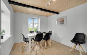 a dining room with a table and black chairs at 3 Bedroom Amazing Home In Sydals in Østerby