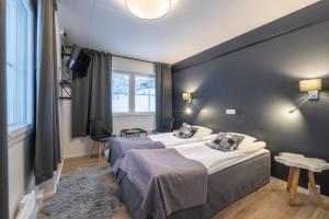 a hotel room with two beds and a window at Kuukkeli Saariselkä Inn in Saariselka