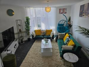 a living room with a green couch and chairs at 1 Bed - Sleeps 4 - City Centre in Wolverhampton