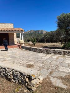 a person standing in front of a building with a stone wall at Villa Casa Onde in Favignana