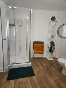 a bathroom with a shower and a toilet and a chair at 1 Bed - Sleeps 4 - City Centre in Wolverhampton