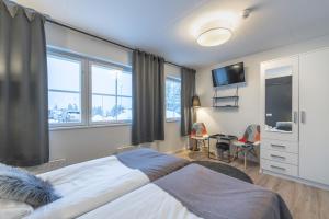 a bedroom with a large bed with a tv on the wall at Kuukkeli Saariselkä Inn in Saariselka