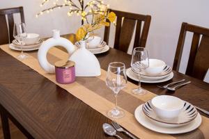 a wooden table with plates and wine glasses on it at Hanoi Nest Seekers -New Branding - WestLake view Building in Hanoi