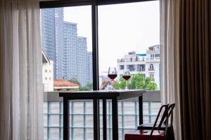 two glasses of wine sitting on a table in front of a window at Hanoi Nest Seekers -New Branding - WestLake view Building in Hanoi